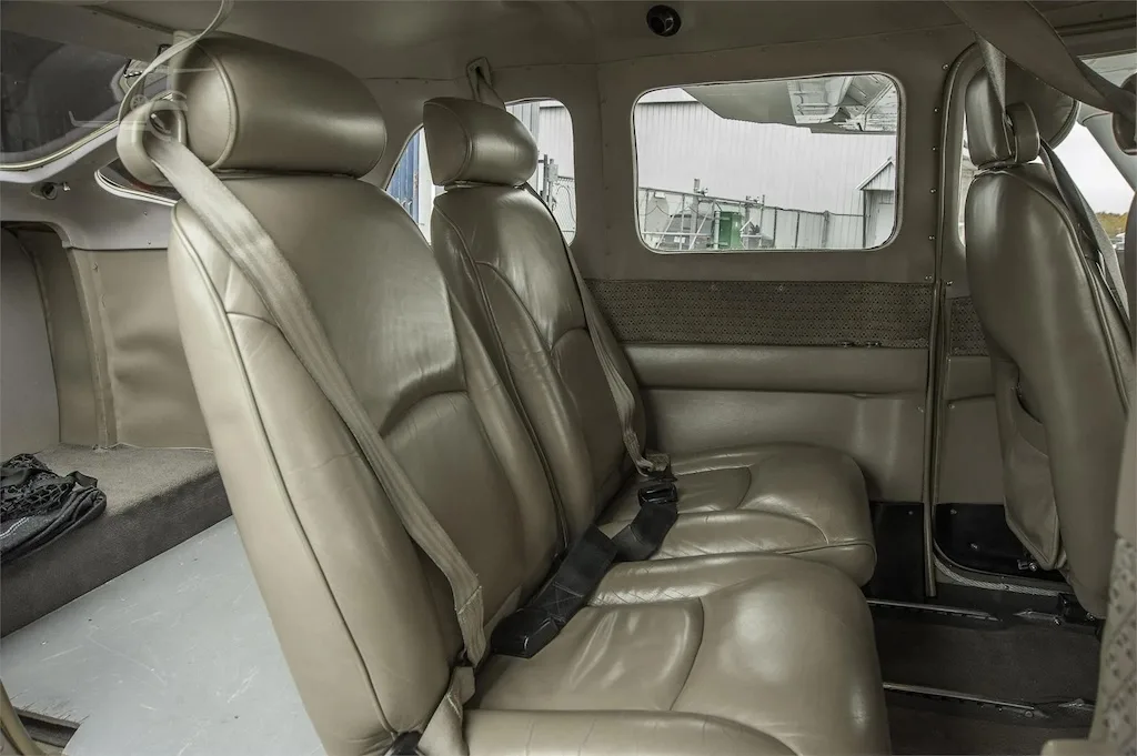 A close-up view of the tan leather rear seats inside the aircraft cabin.