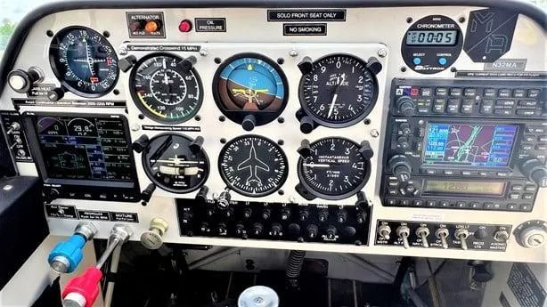 The instrument panel of an Aviat Husky A-1C aircraft features analog gauges and modern digital avionics, with "N32MA" visible on the chronometer.