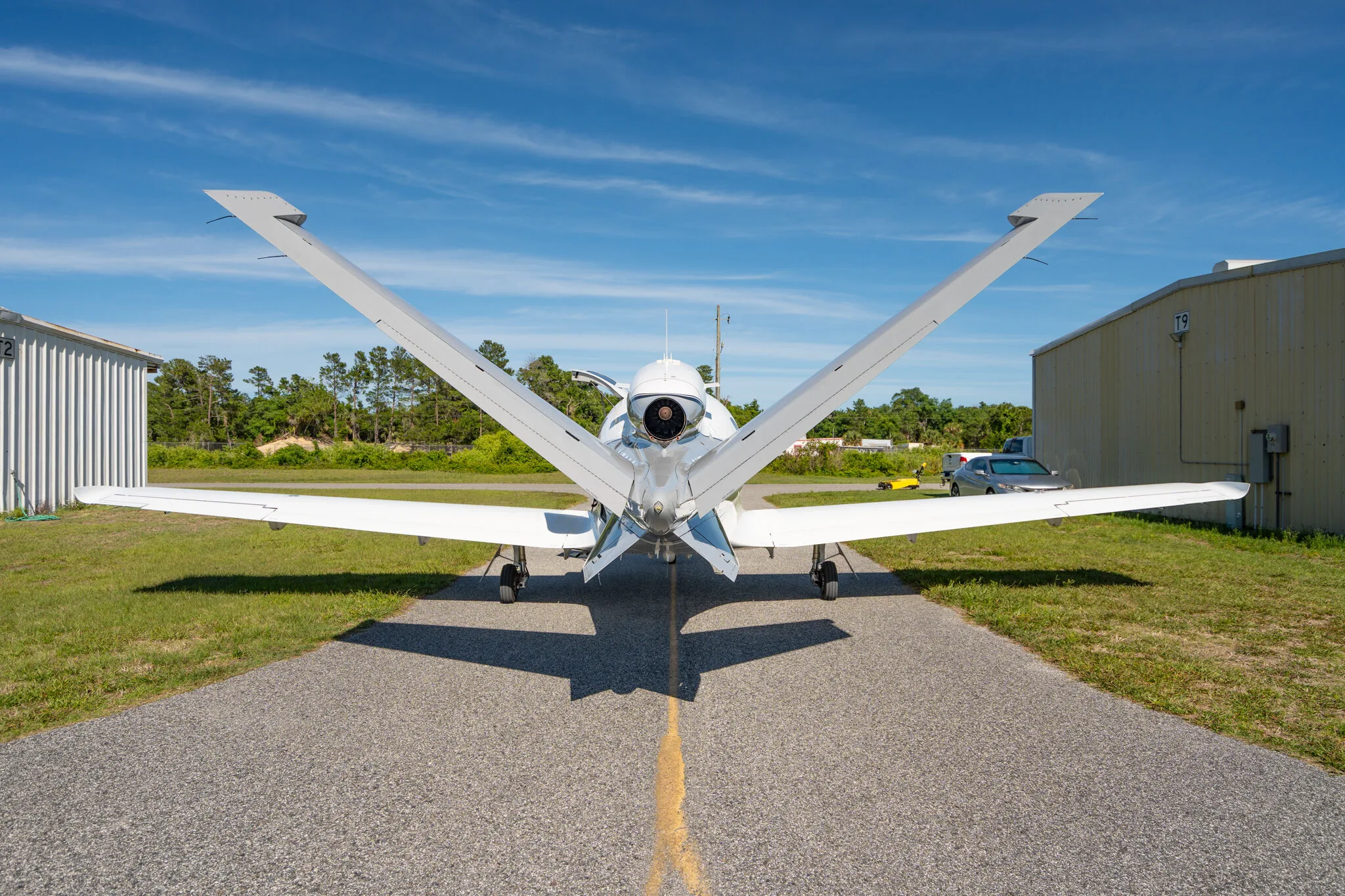 Rear view of a white and grey Cirrus Vision Jet N73SG on an airfield.