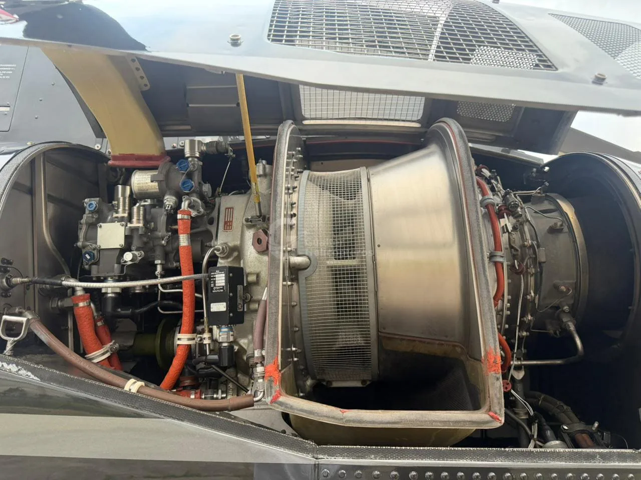 An open engine bay of a helicopter showing the turbine engine and associated components.