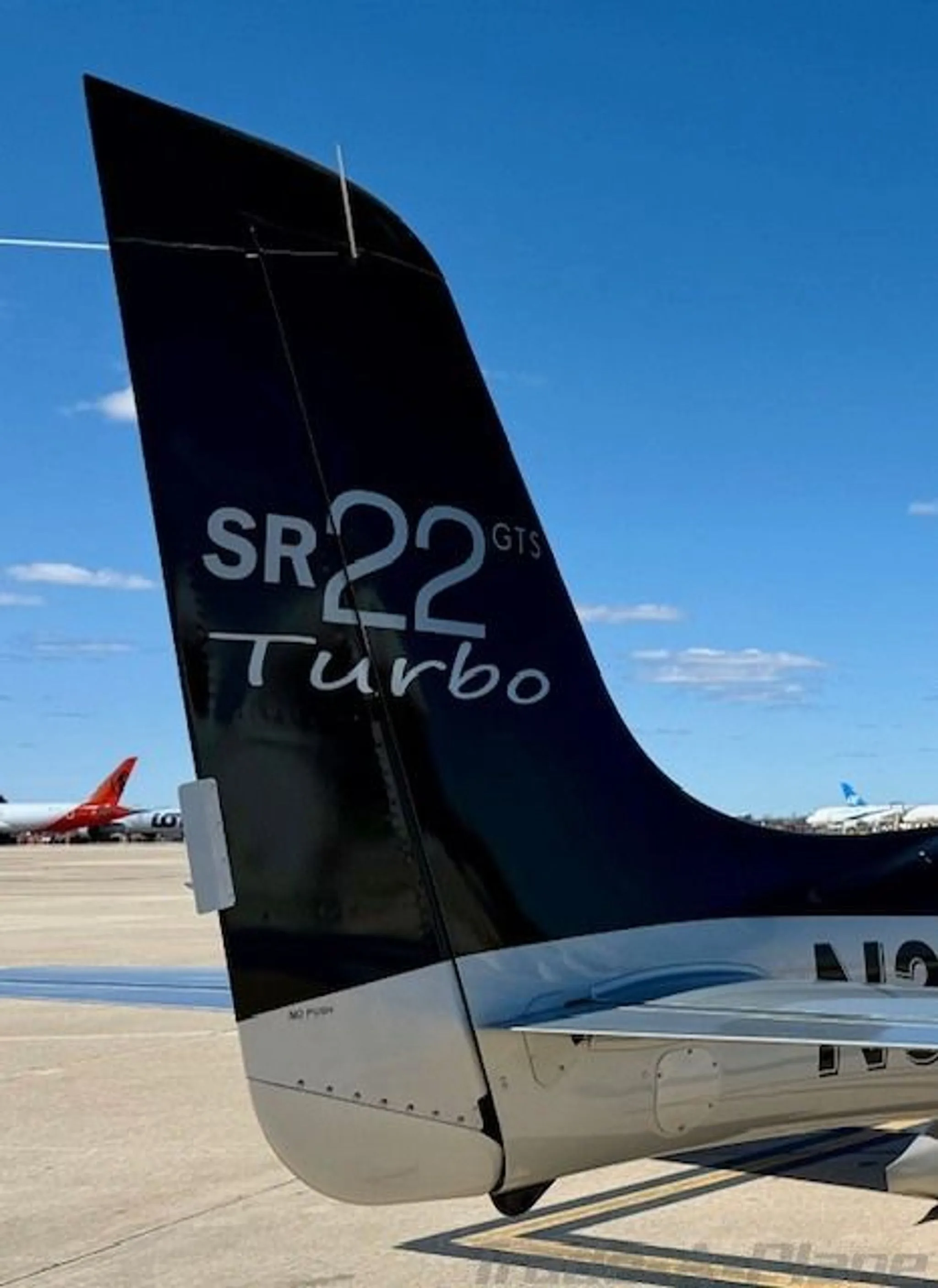 A close-up view of the black tail of a Cirrus SR22 GTS Turbo aircraft, showing the model designation and registration N344A.