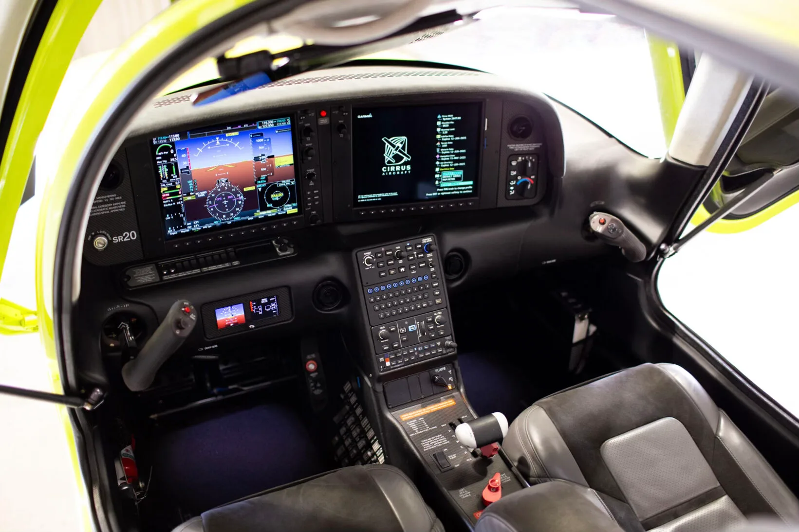 Wide view of the Cirrus SR20 cockpit showing the instrument panel and gray seats.