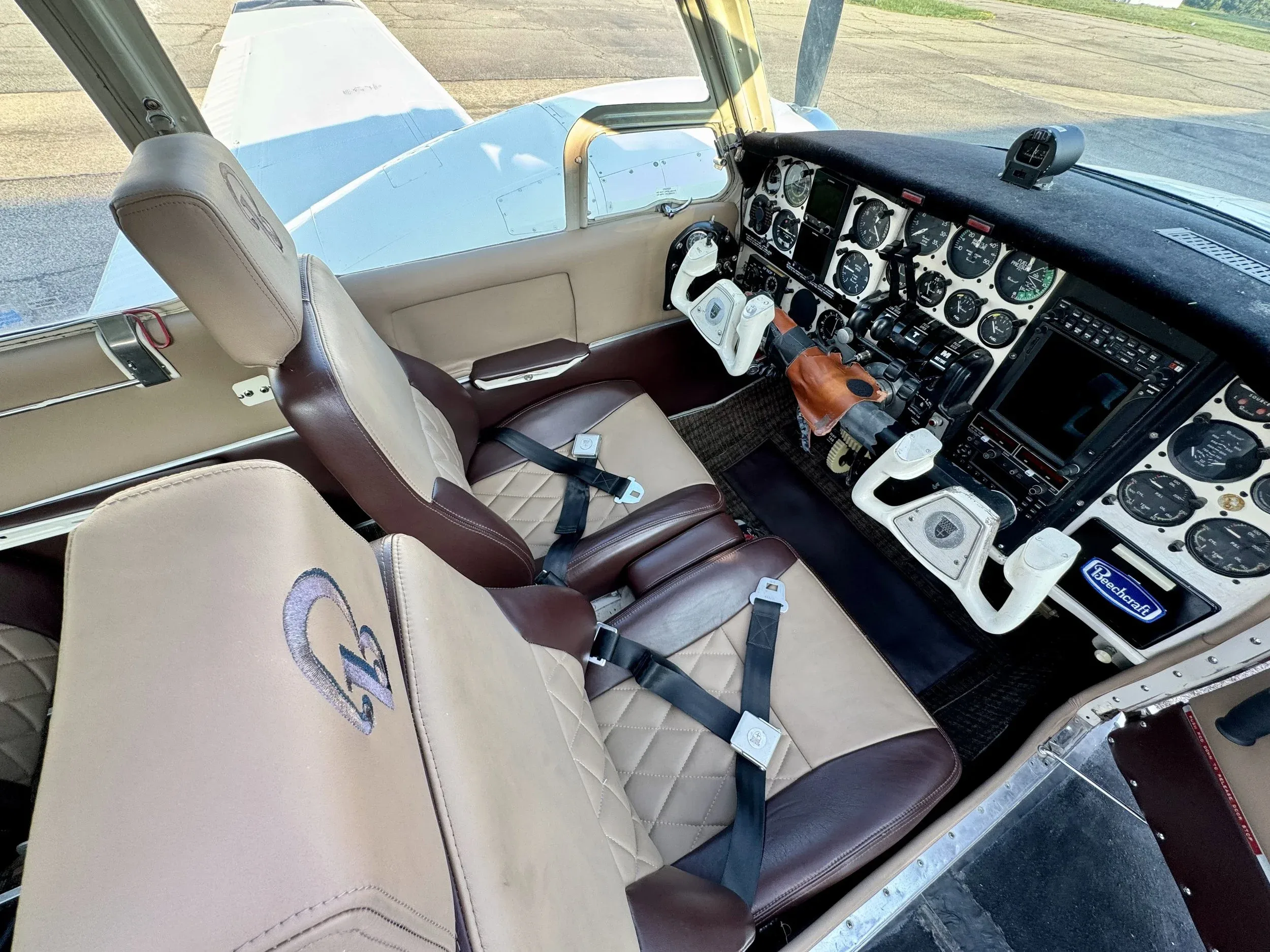 View of the cockpit and front seats of the Beechcraft Baron B55, showing the instrument panel and interior details.