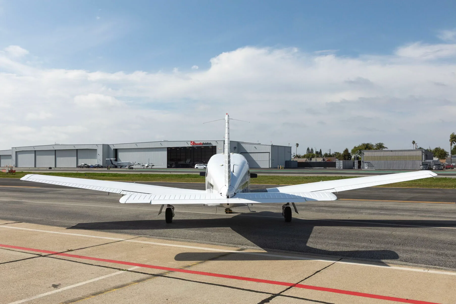 A rear view of a white Piper PA-28-181 Archer III aircraft parked on an airfield.