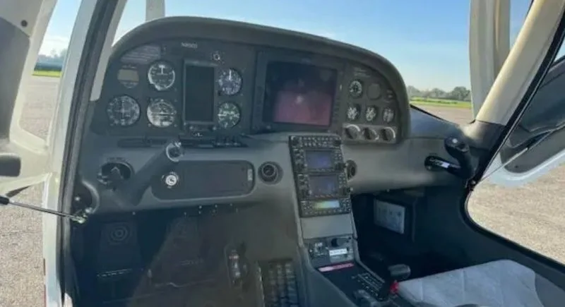 A close-up view of the Cirrus SR20 cockpit dashboard with multiple screens and instruments.