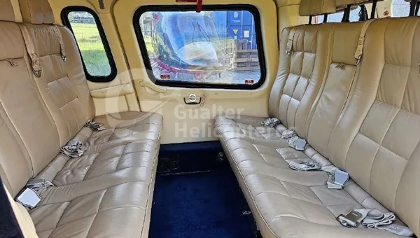 The beige leather passenger seats in the rear cabin of a helicopter.