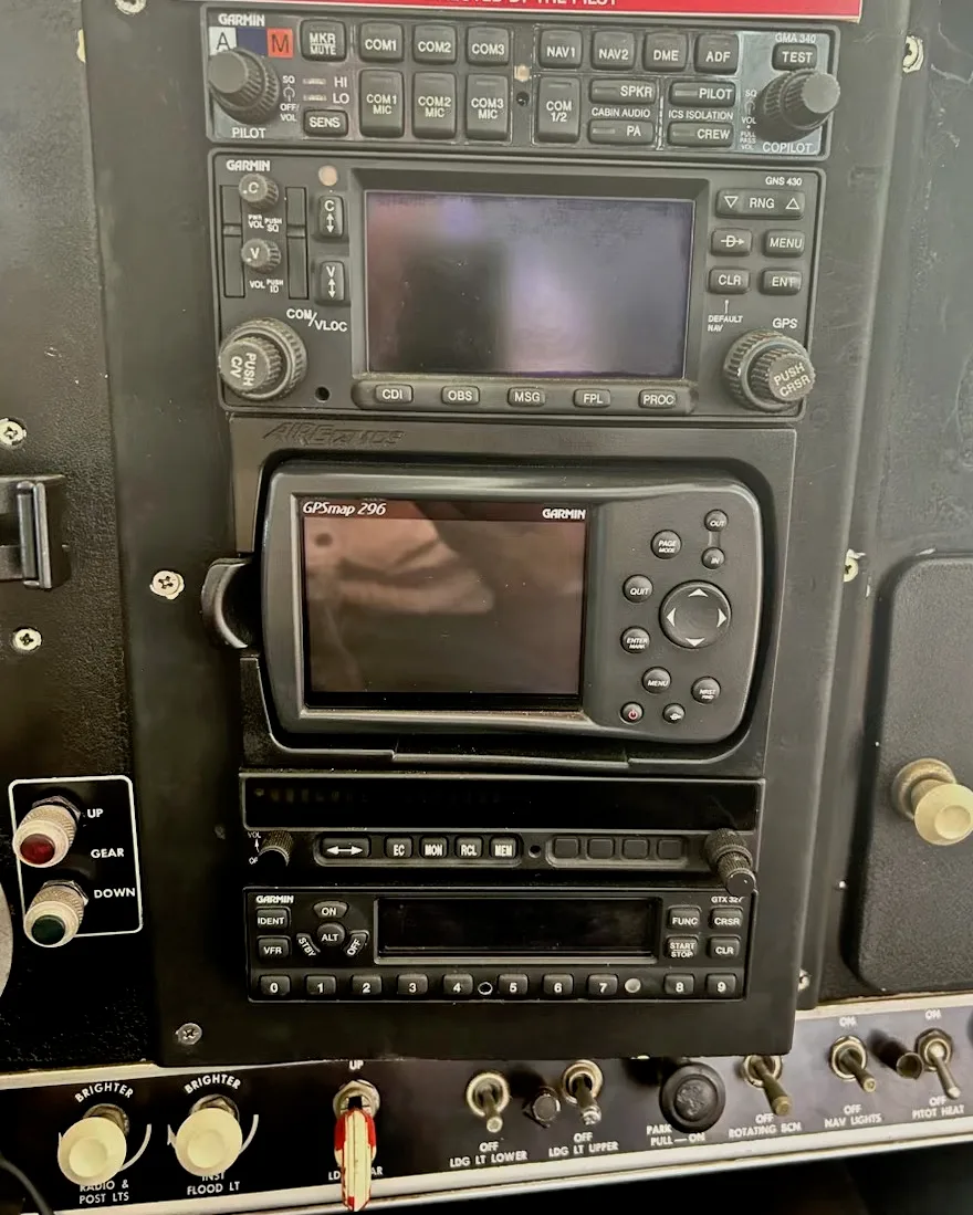A close-up view of an aircraft's avionics stack, featuring multiple Garmin radios and GPS units.