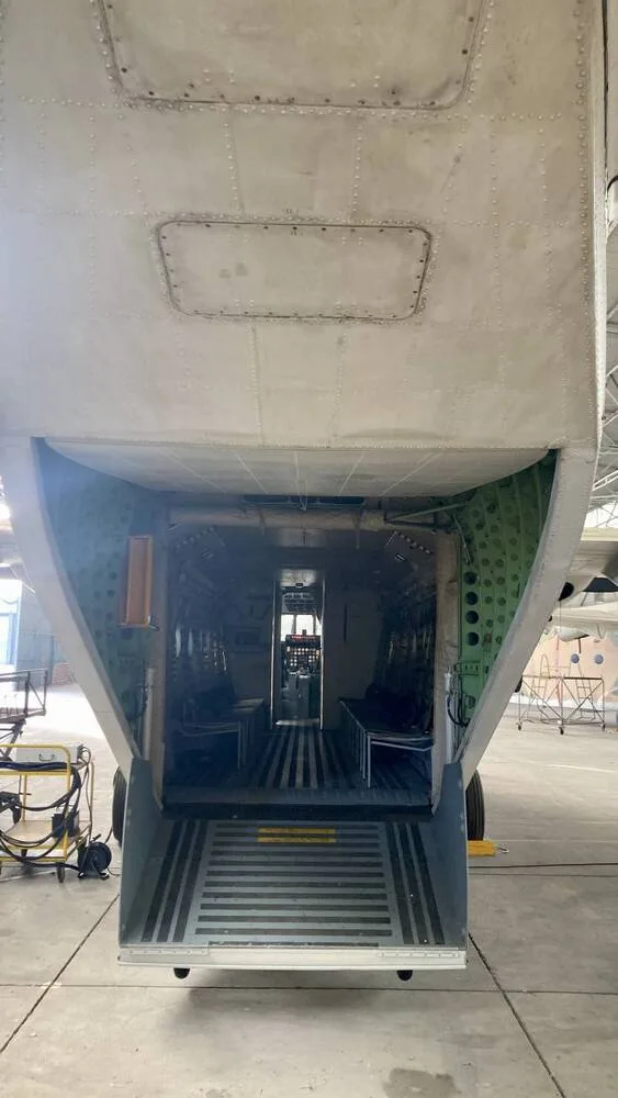 The open rear cargo ramp and interior of a military transport aircraft's cargo hold.