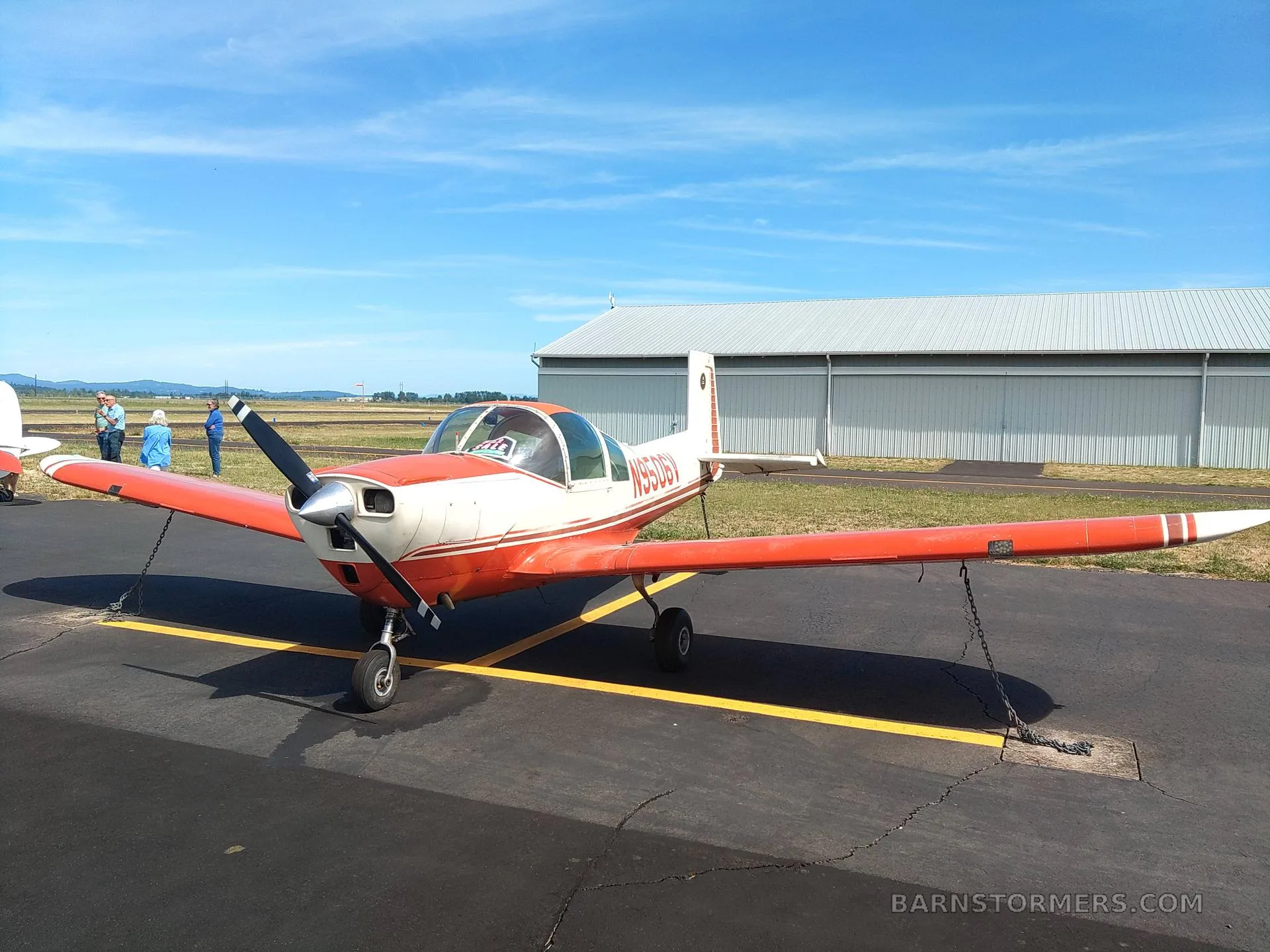 The aircraft's interior features two-tone red and tan seats with seatbelts.