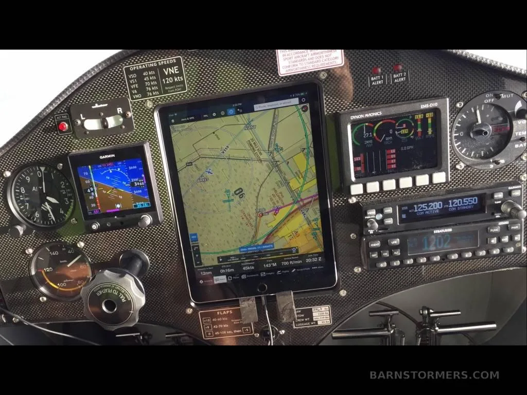 The cockpit instrument panel of an aircraft, featuring a central tablet display and various gauges.