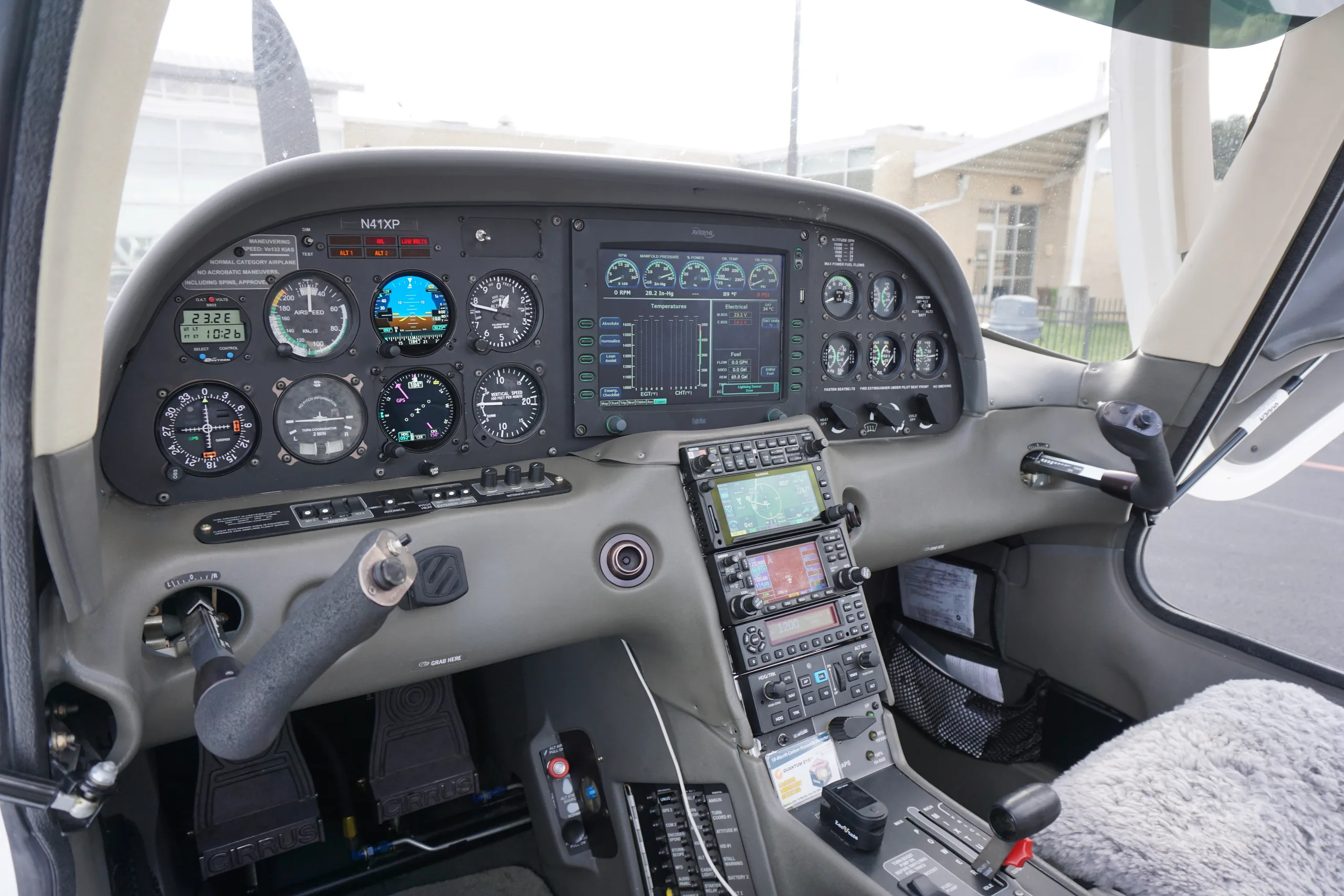 View of the Cirrus SR22 cockpit with a glass panel display, traditional gauges, and the N-number "N41XP" visible.