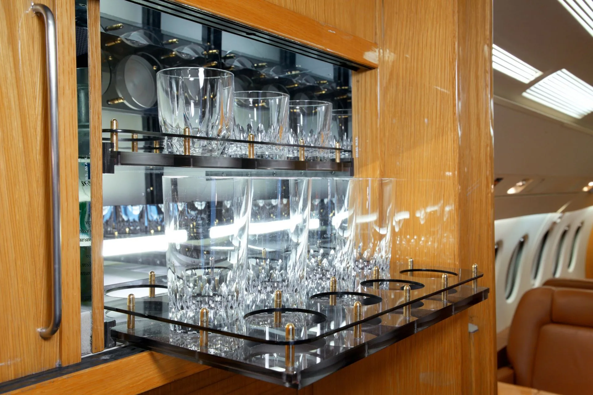 A close-up of the aircraft's bar area with crystal glasses.