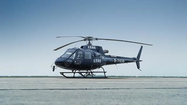 A dark blue Airbus H125/AS350 helicopter with registration B-7436 is parked on an asphalt tarmac, viewed from a slightly different angle.