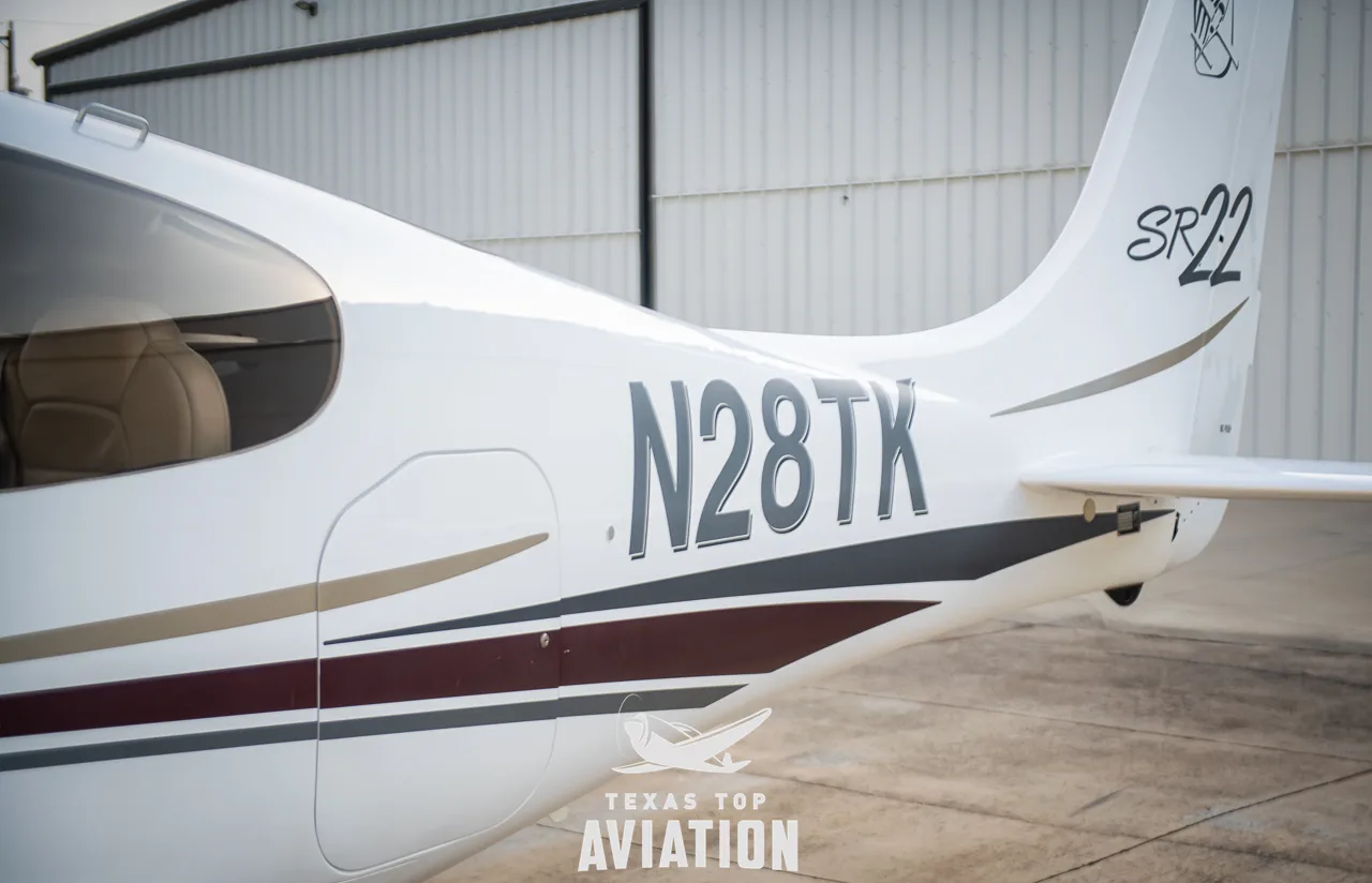 A close-up view of the tail of a white Cirrus SR22 aircraft, showing the registration N28TK and "SR22" logo.