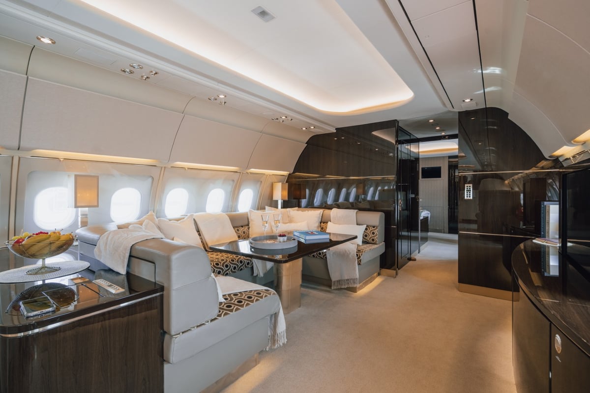 Luxurious aircraft interior with a seating area and table.