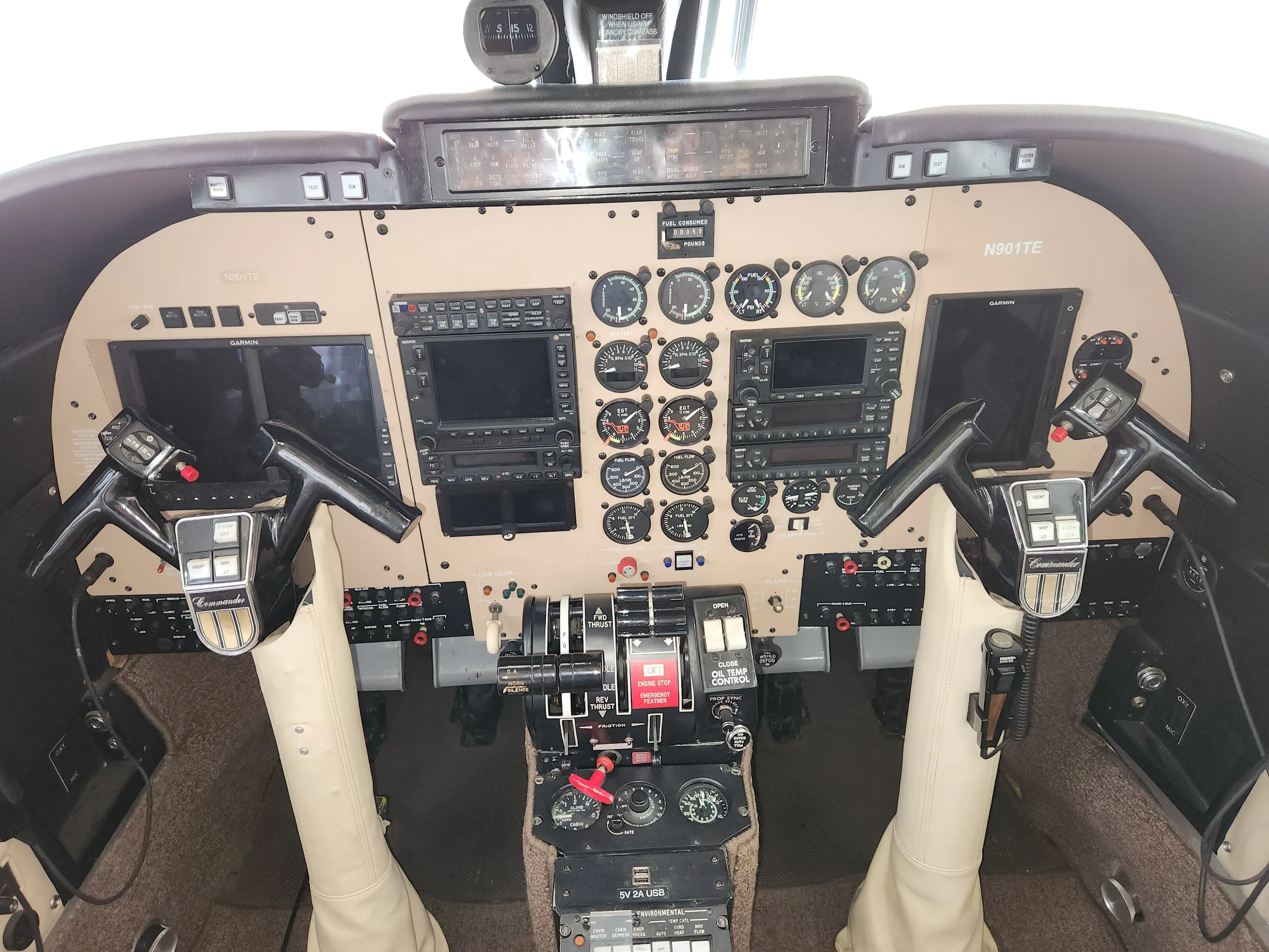 The cockpit of the Commando aircraft features a tan instrument panel and dual yokes.
