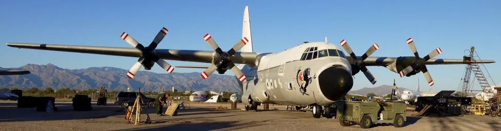 A C-130 Hercules displayed with military vehicles.