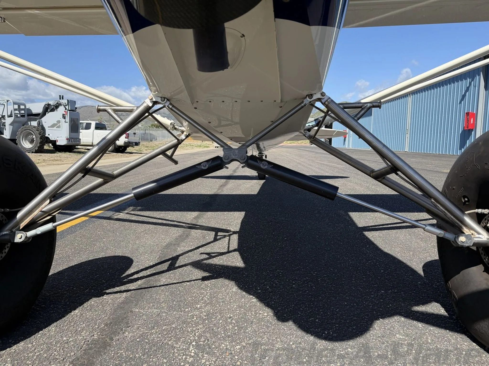 A close-up view of the robust landing gear and large tundra tires of the Carbon Cub SS aircraft.