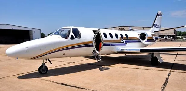 A Cessna Citation CJ1+ aircraft with its door open on the tarmac.