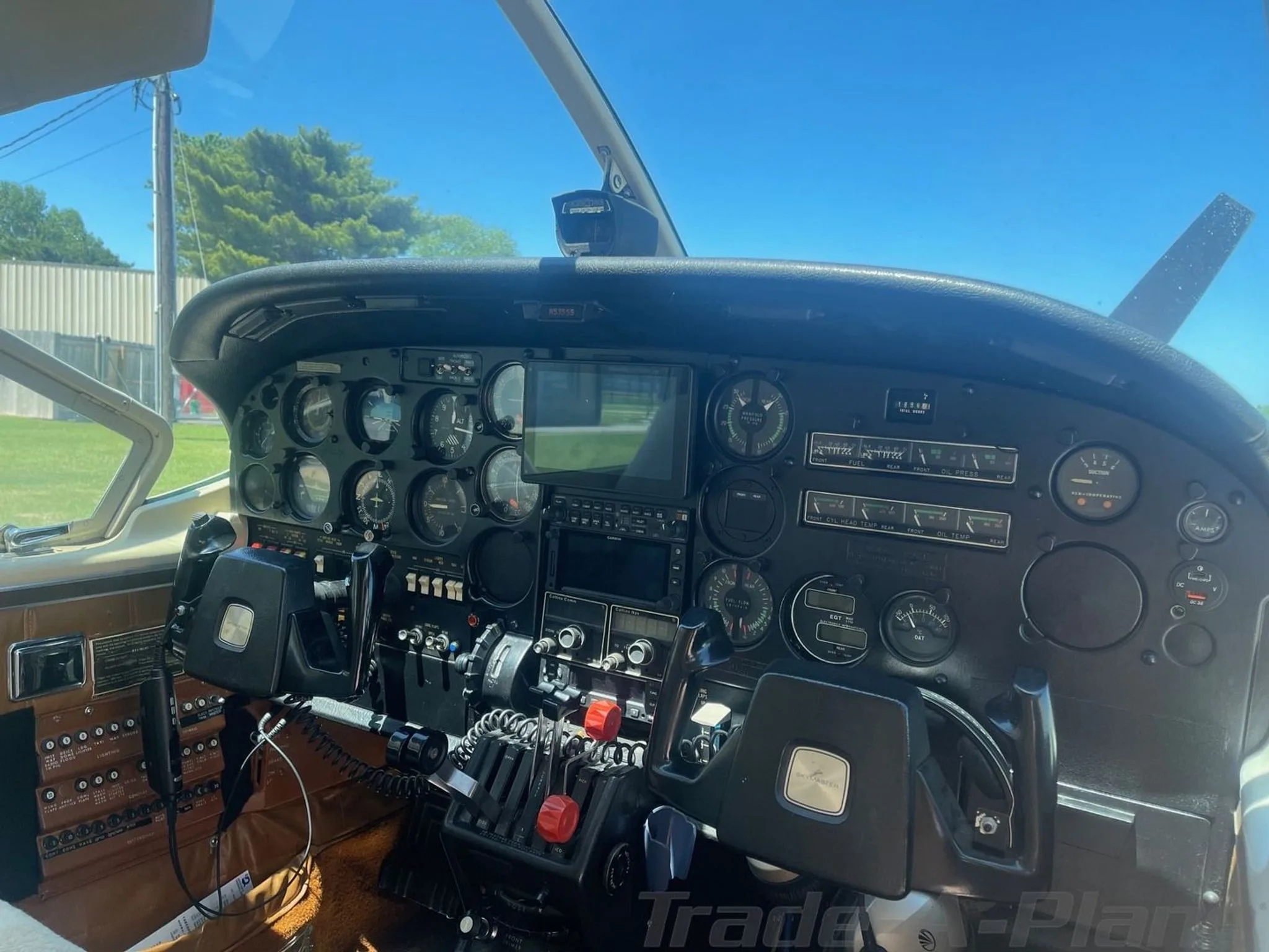 The cockpit of a Cessna 206, showing the instrument panel, yokes, and throttle quadrant.