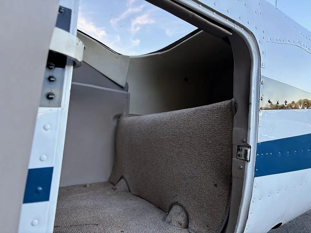 The open cargo door and carpeted cargo area of a small aircraft.