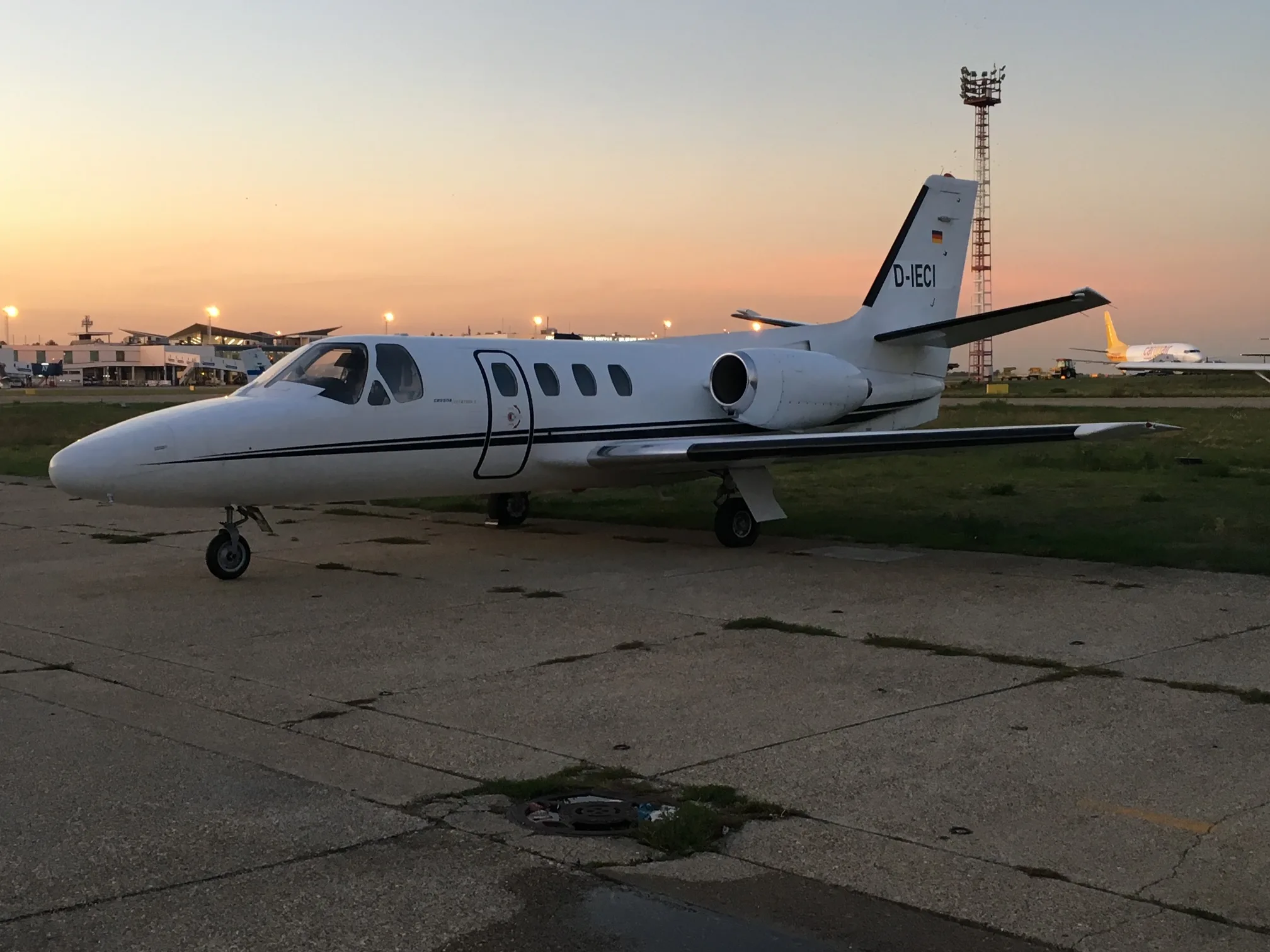 A Cessna Citation Mustang aircraft, registration D-IECI, parked on the tarmac at dusk.