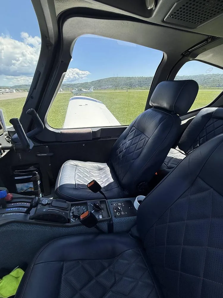 The front cabin seats of the Socata Trinidad aircraft, upholstered in dark blue diamond-stitched leather.