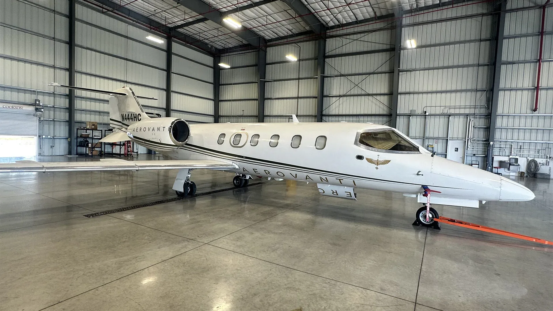 A Learjet 25D aircraft is parked inside a hangar, showcasing its white and black paint scheme.