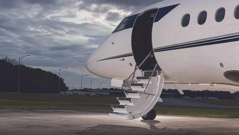 A close-up view of the open main entry door with integrated stairs on the white business jet N88GD.