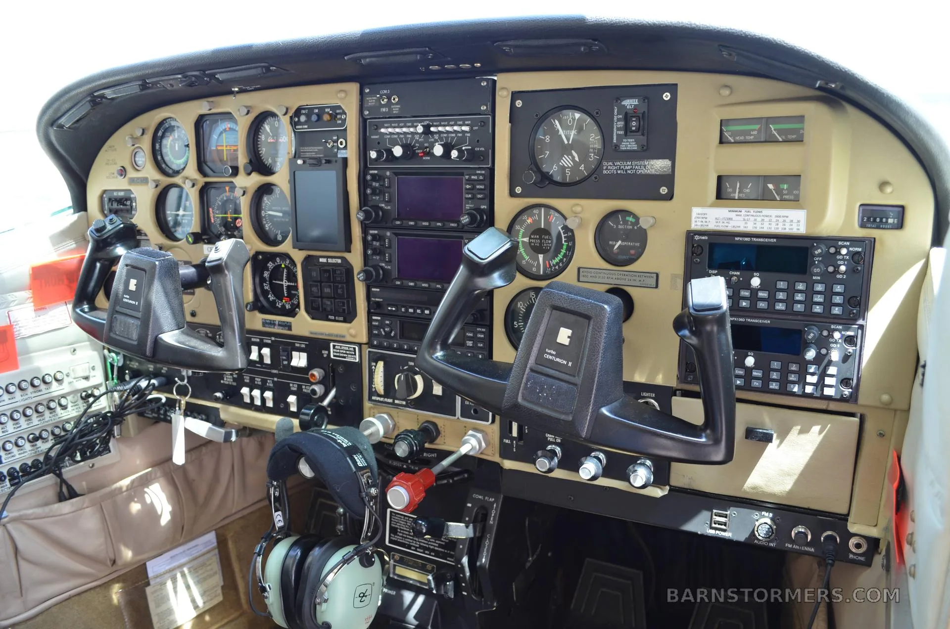 A wide view of the Cessna Centurion II cockpit, featuring the instrument panel with dual yokes, gauges, and avionics.
