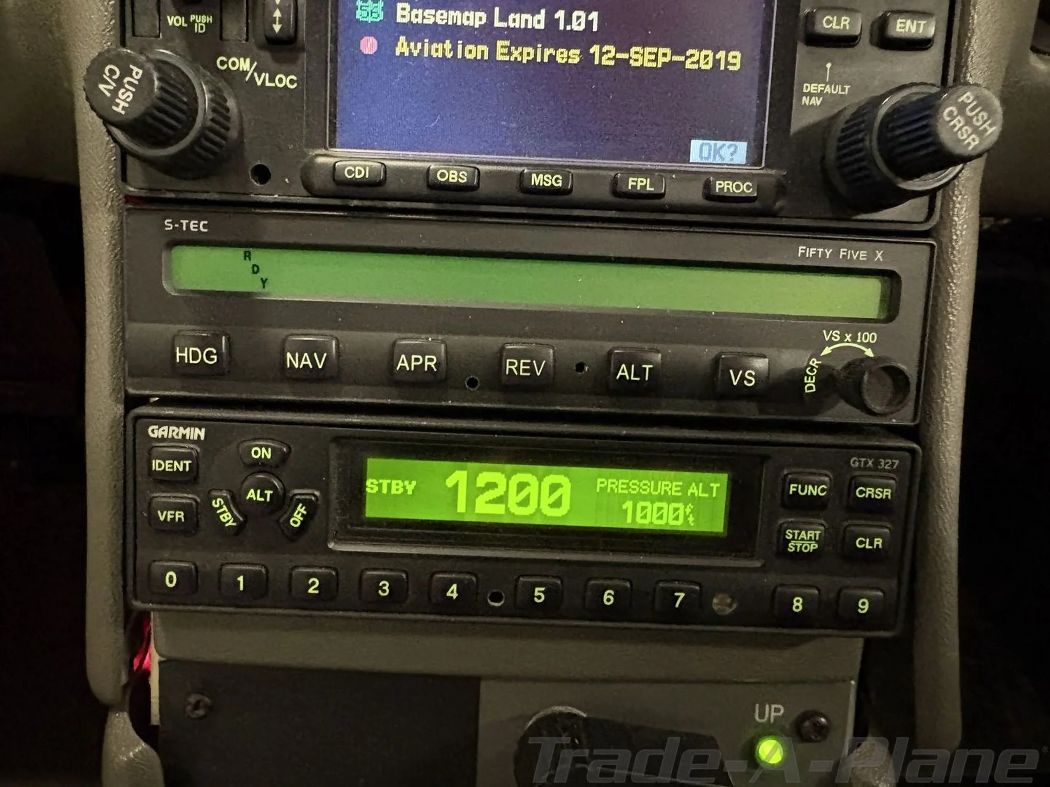 A close-up view of the avionics stack in a Cirrus SR20 cockpit, showing a Garmin transponder and S-TEC autopilot.
