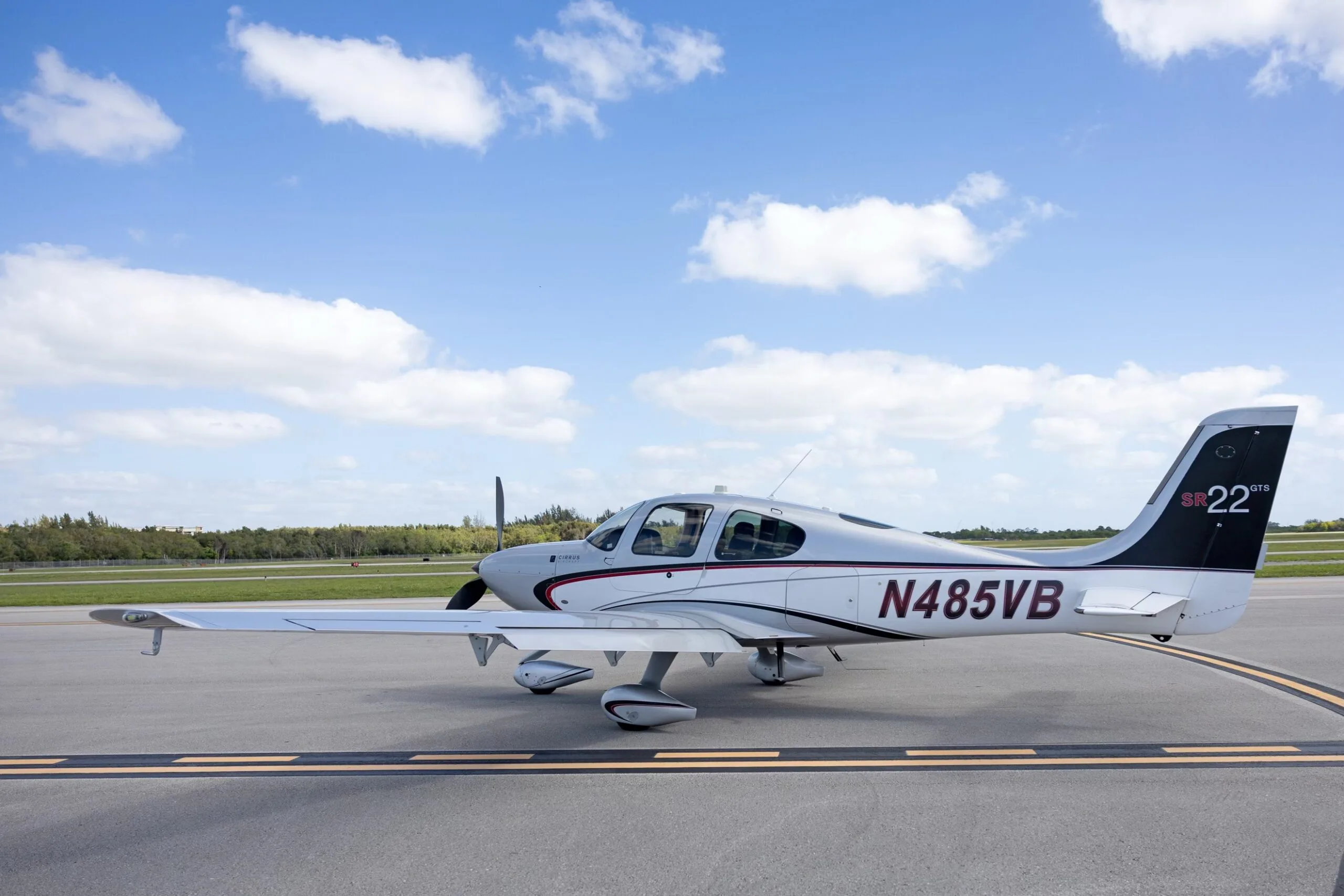A side view of the silver Cirrus SR22 GTS aircraft N485VB, showing its registration and tail markings, parked on an airfield.