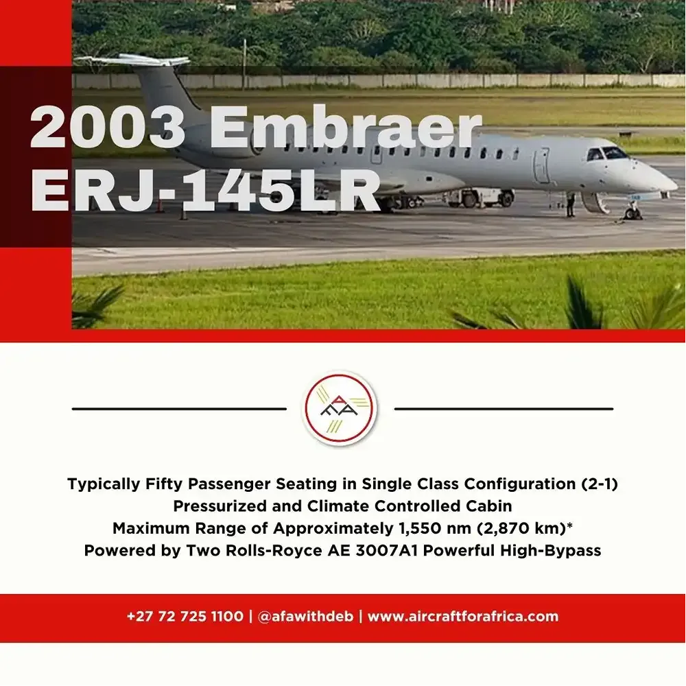 A grey Embraer ERJ-145LR regional jet parked on an airport tarmac with green grass and trees in the background.