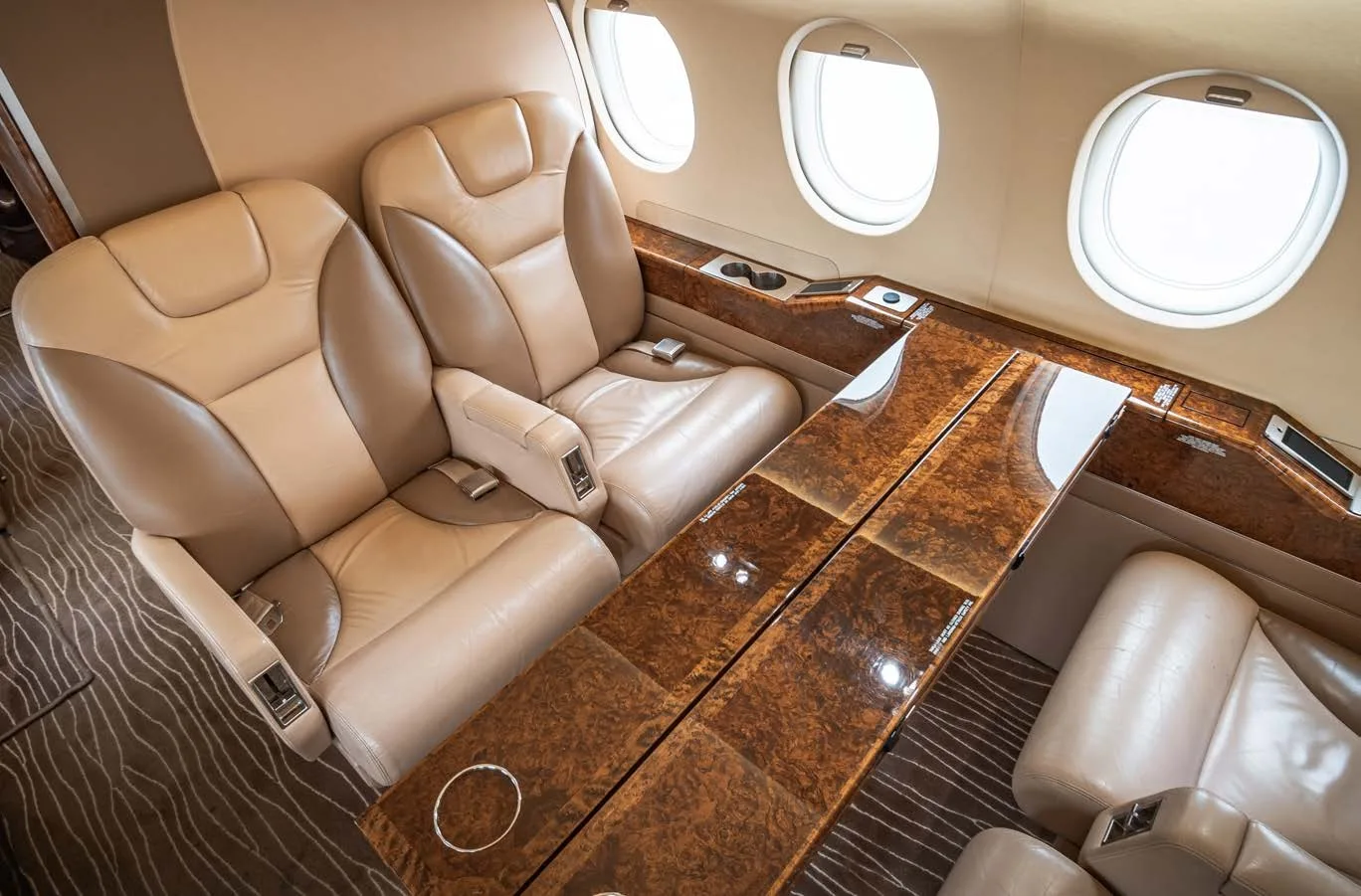 Interior view of the aircraft cabin with leather seats and a table.