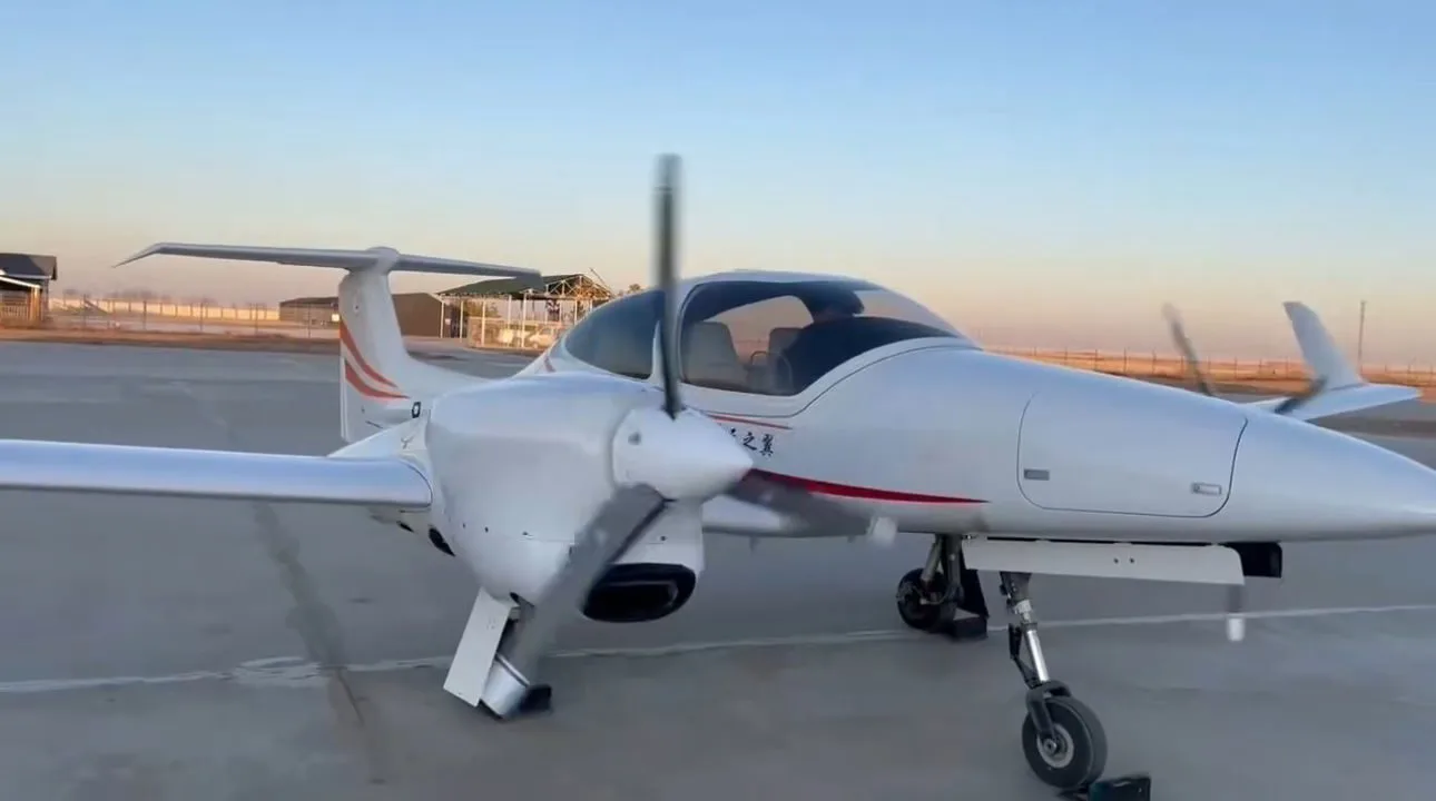 Diamond DA42 aircraft on the tarmac with spinning propellers.