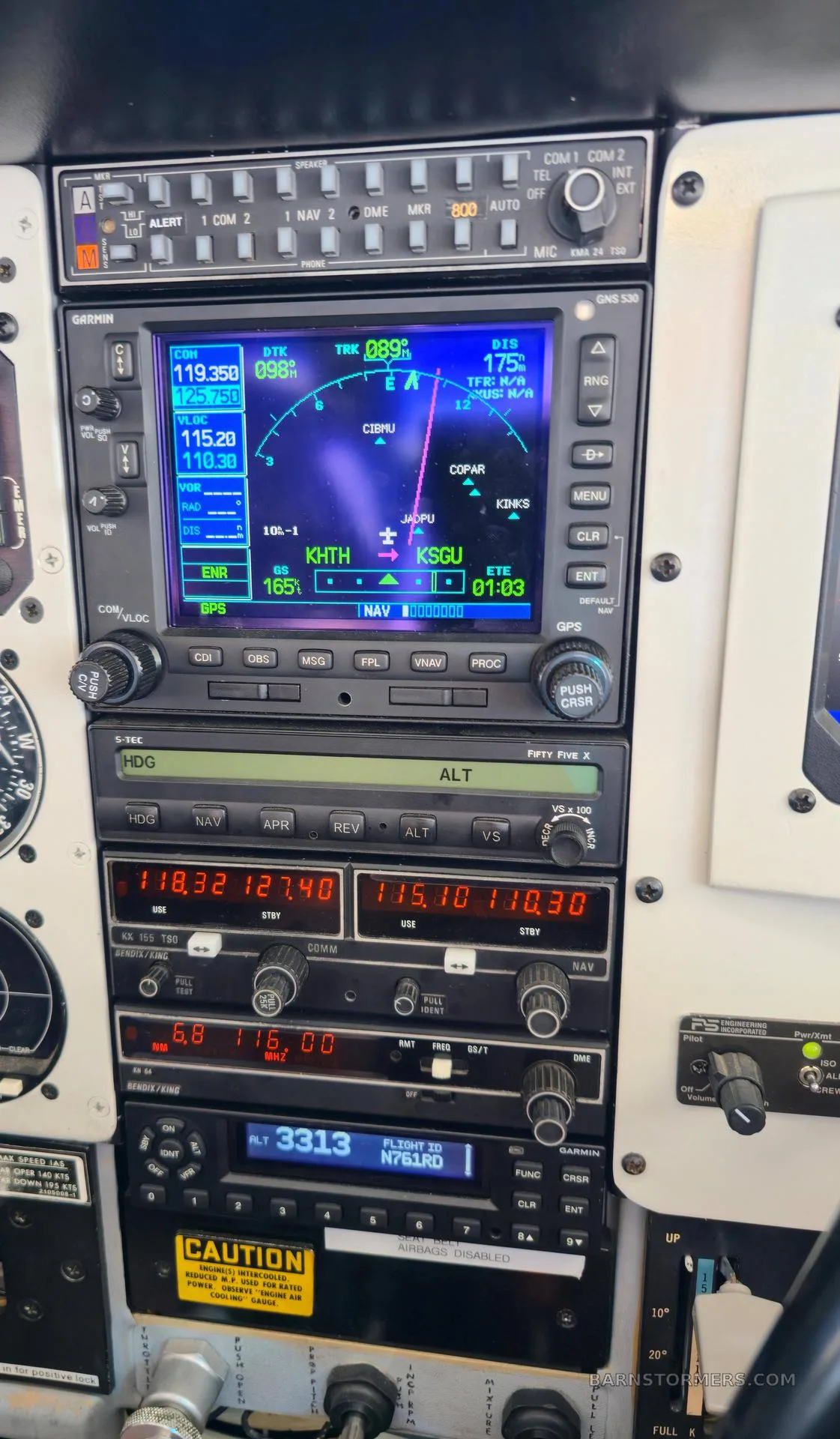 A detailed view of an aircraft's avionics stack, showing a Garmin GNS 530 and various communication and navigation radios.