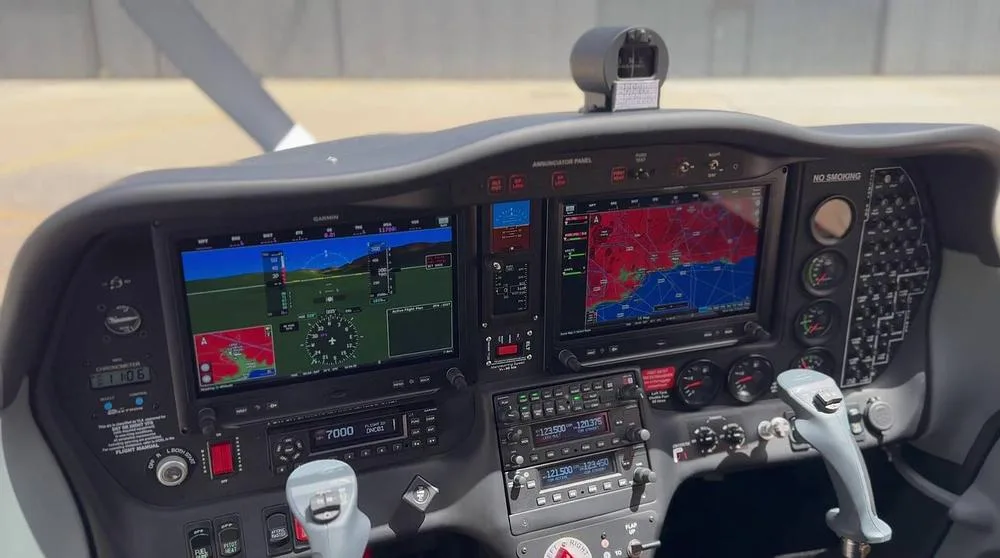 A detailed view of the Tecnam P2008 cockpit instrument panel, featuring two large Garmin G3X Touch displays and various controls.