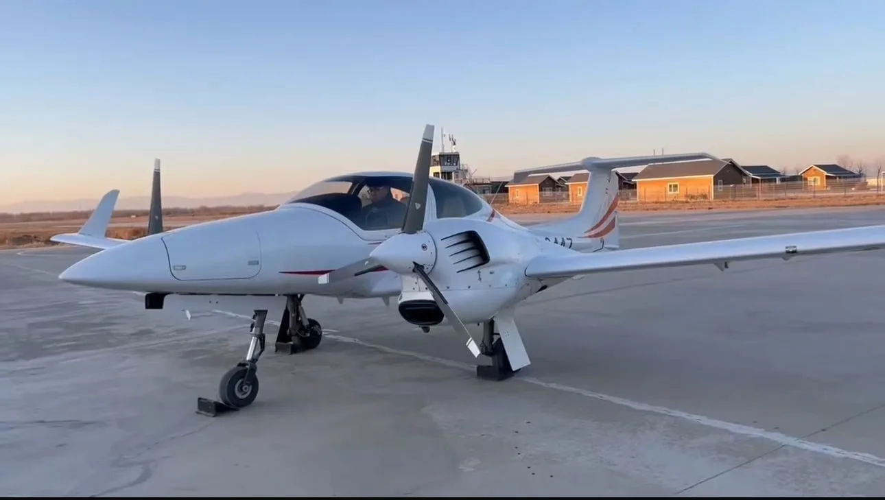 Diamond DA42 aircraft on the tarmac with a pilot visible in the cockpit.