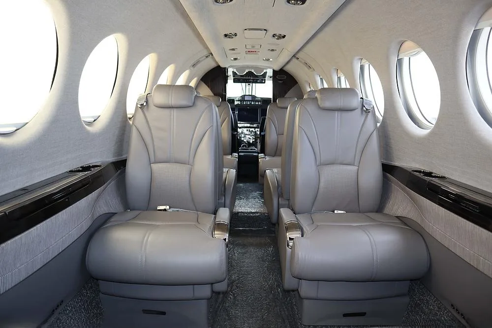 The aircraft's grey leather cabin interior, looking forward towards the cockpit.