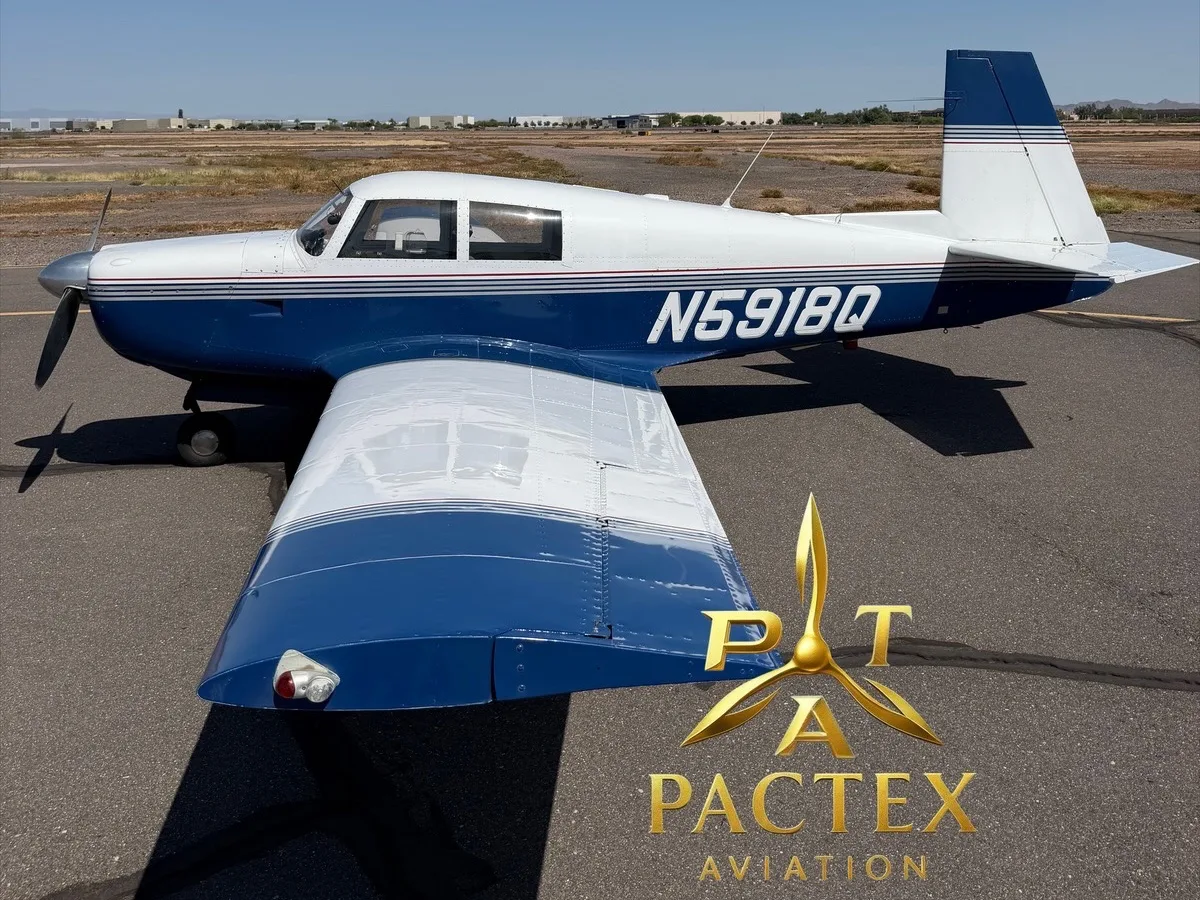 A white and blue single-engine propeller aircraft, registration N5918Q, parked on an asphalt runway under a clear sky.