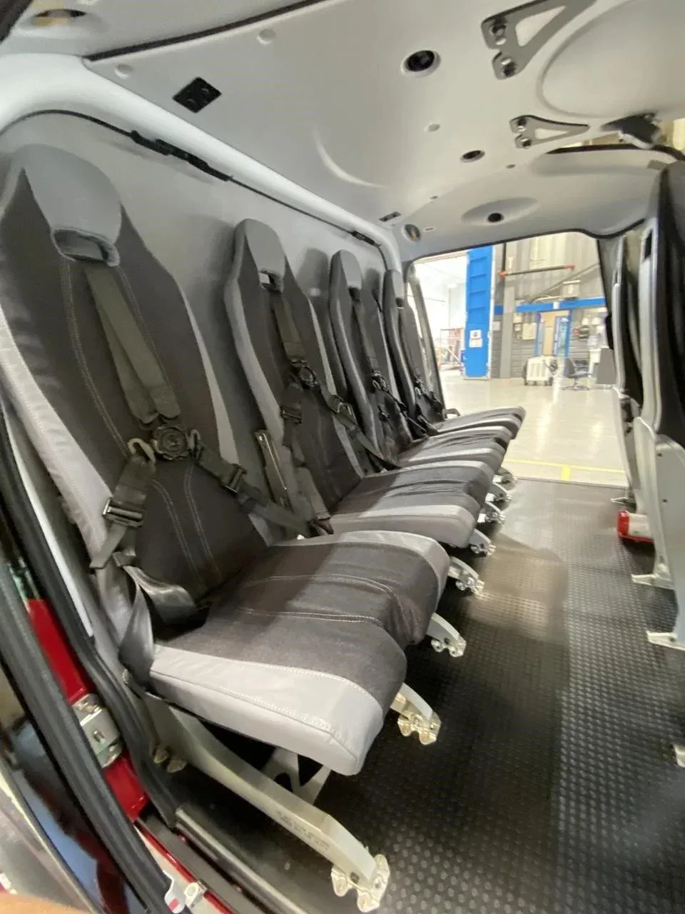 The grey and black passenger seats in the cabin interior of the helicopter.