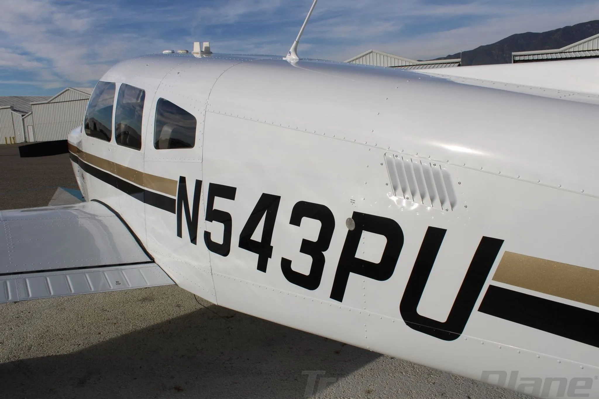 A close-up side view of the N543PU Piper aircraft fuselage, highlighting the registration and air vents.