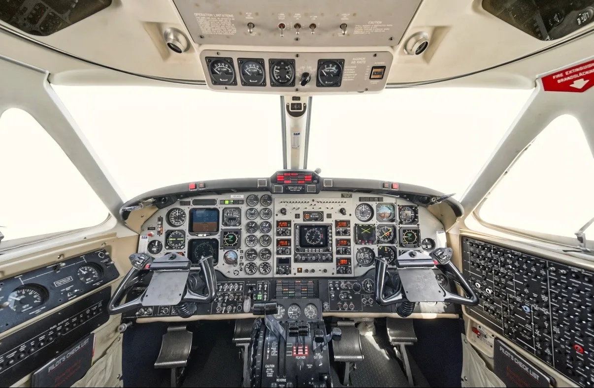 The aircraft's cockpit displays a comprehensive instrument panel with various gauges, screens, and control yokes.