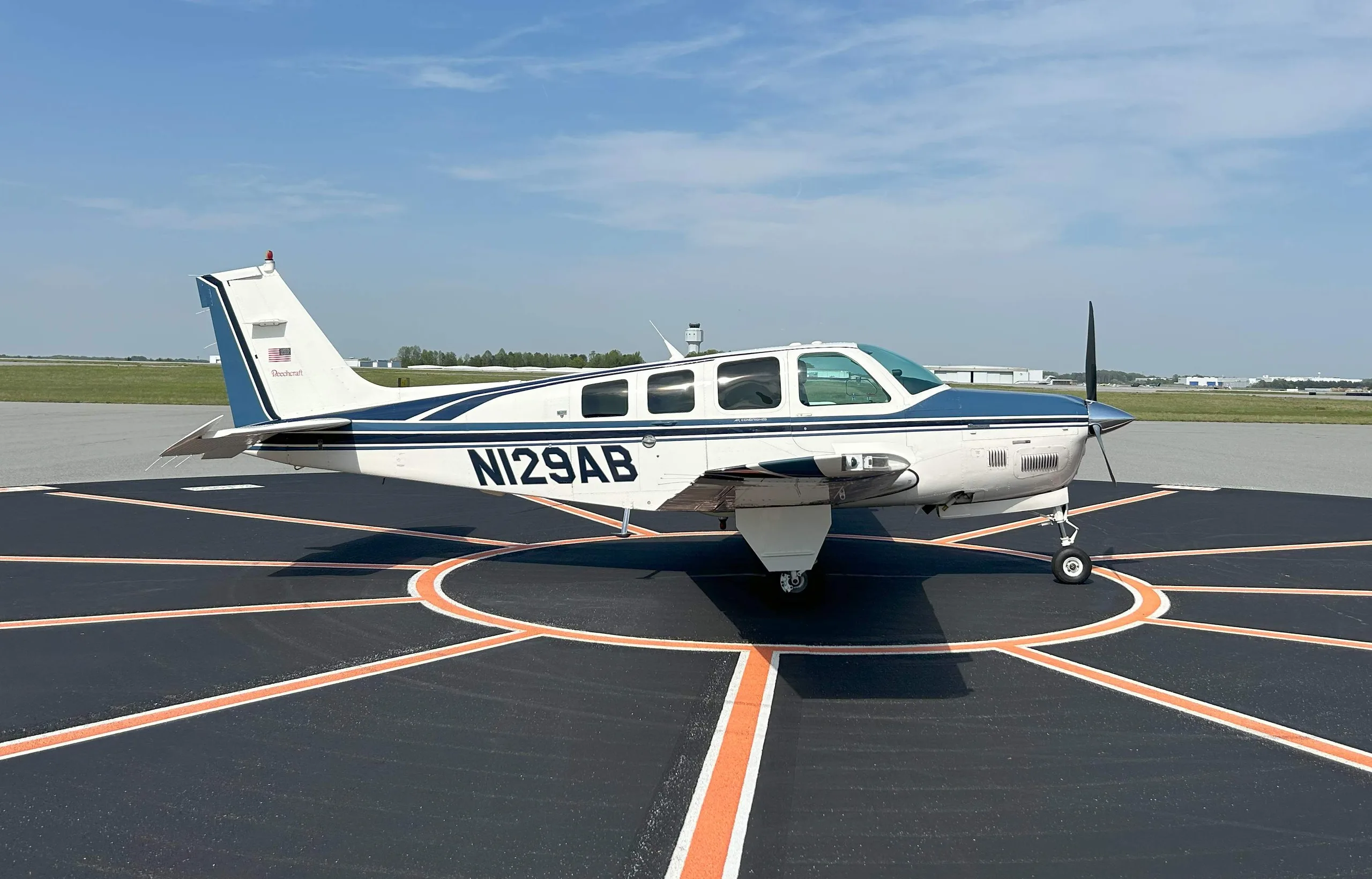Beechcraft Baron on the tarmac with white and blue paint scheme.
