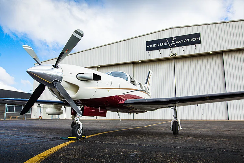 A Meridian aircraft parked in front of a hangar with the Vaerus Aviation logo.
