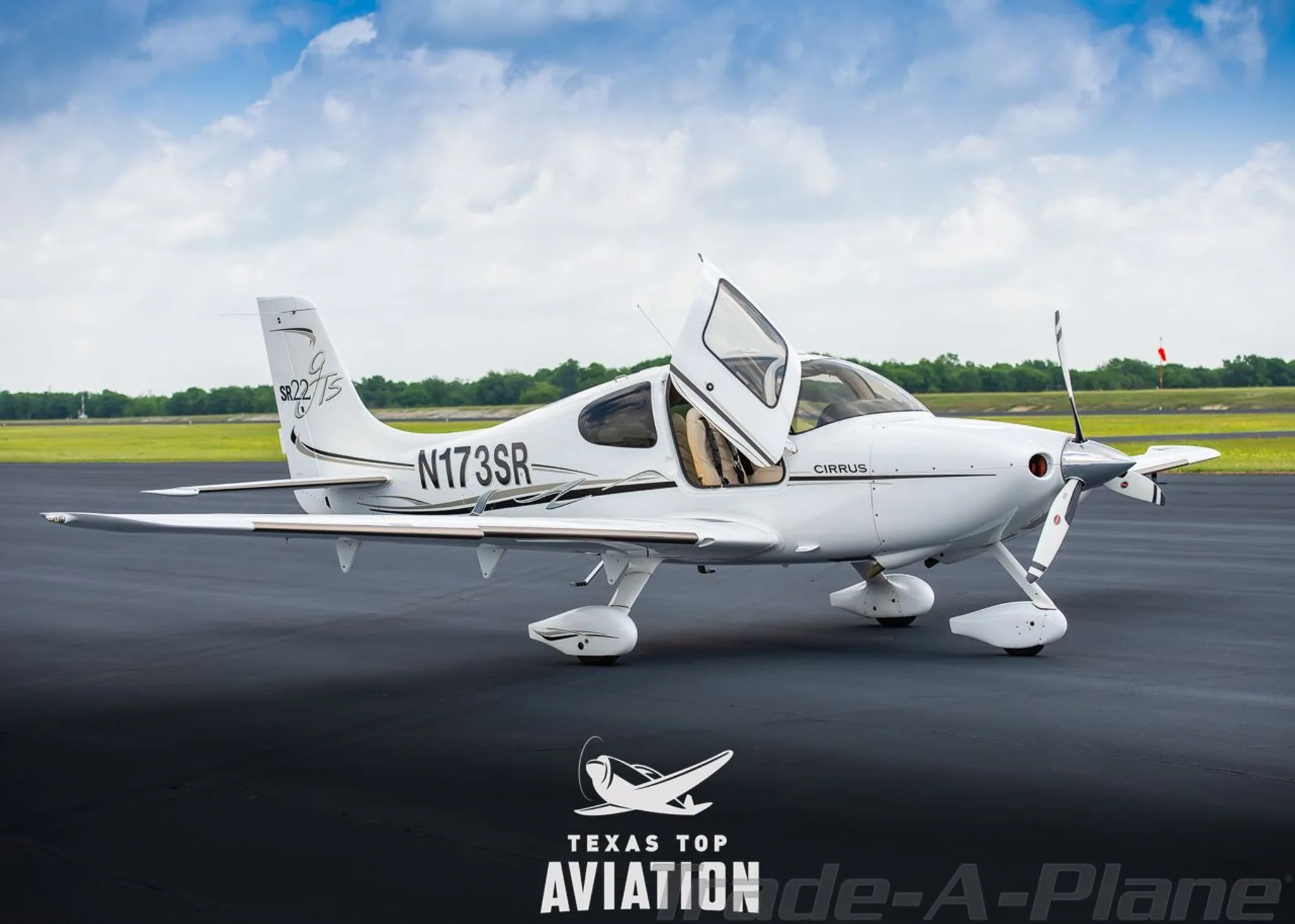 A white Cirrus SR22 aircraft, registration N173SR, parked on an airfield with the pilot's side door open.
