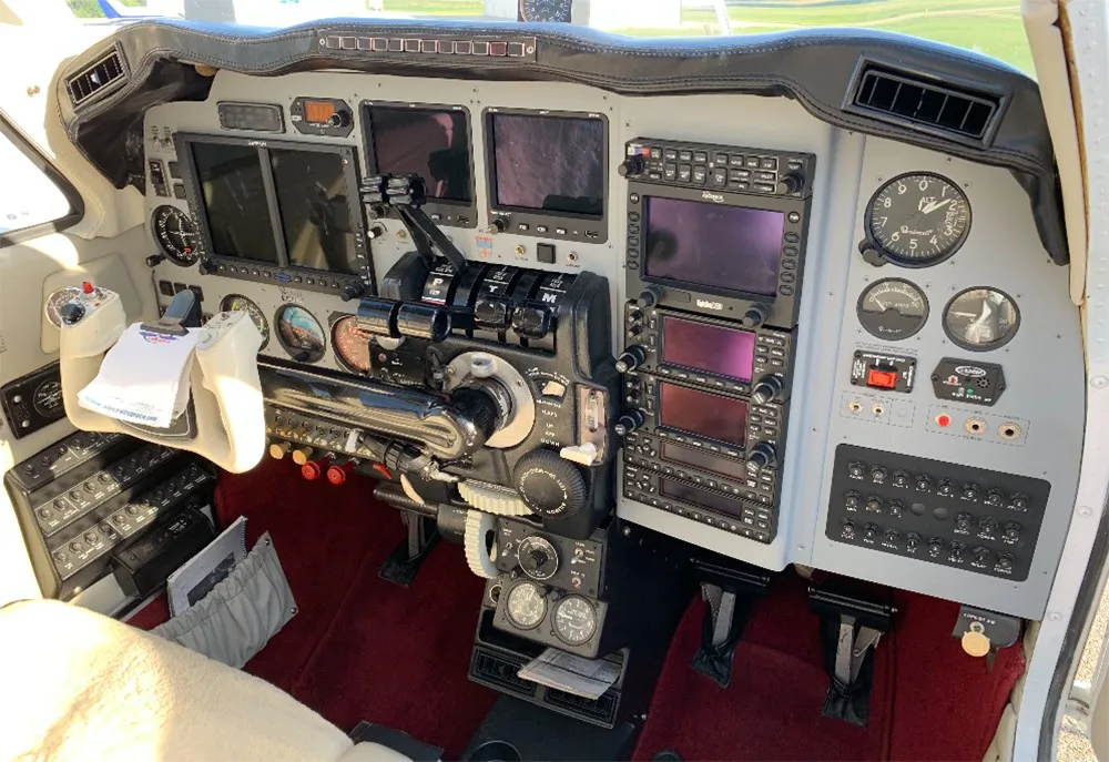 The cockpit of a Beechcraft Baron features a modern glass panel with multiple displays and traditional controls.