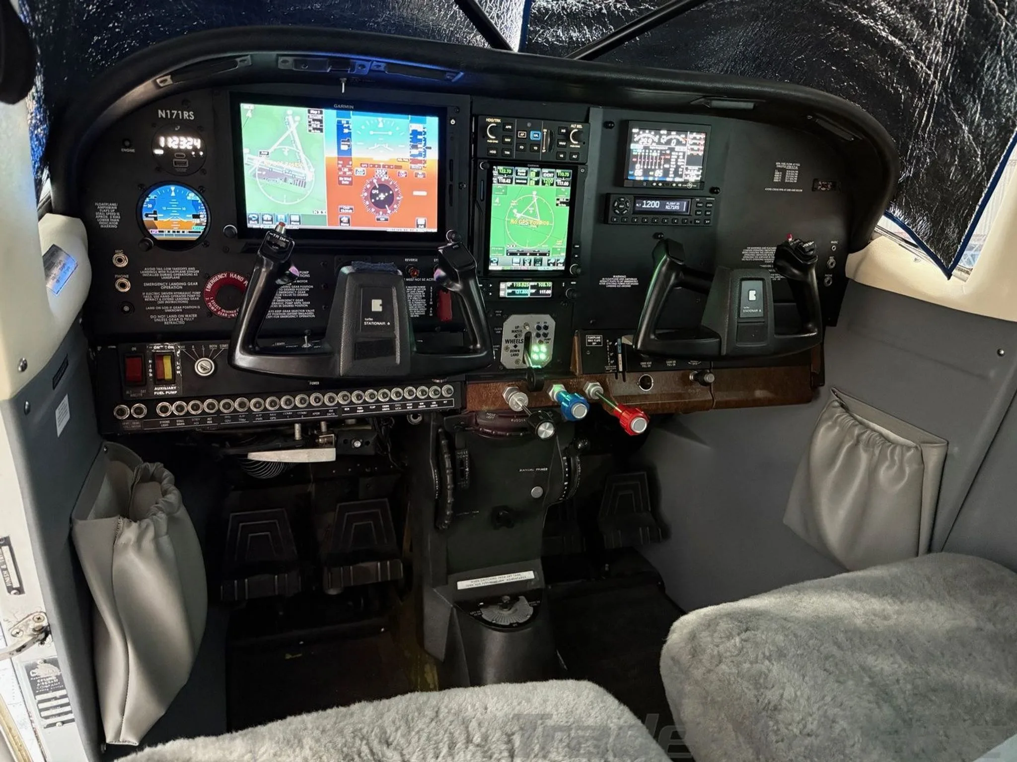 The modern glass cockpit of the Cessna 206 Stationair, featuring multiple Garmin displays.