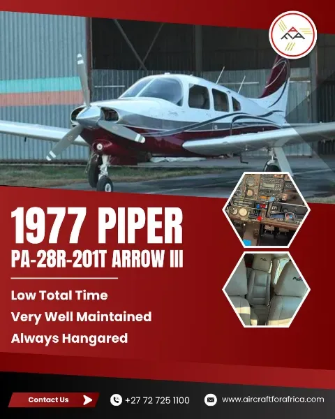 A white and maroon Piper PA-28R-201T Arrow III aircraft is parked in front of a hangar.