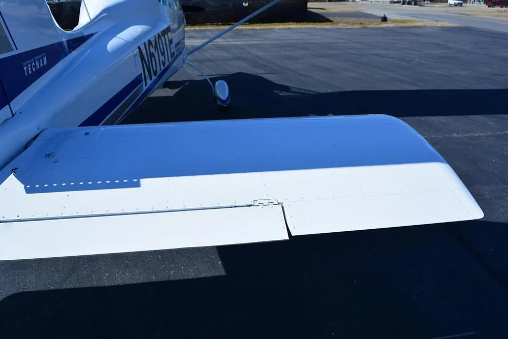 A close-up view of the white horizontal stabilizer and elevator of a Tecnam aircraft.